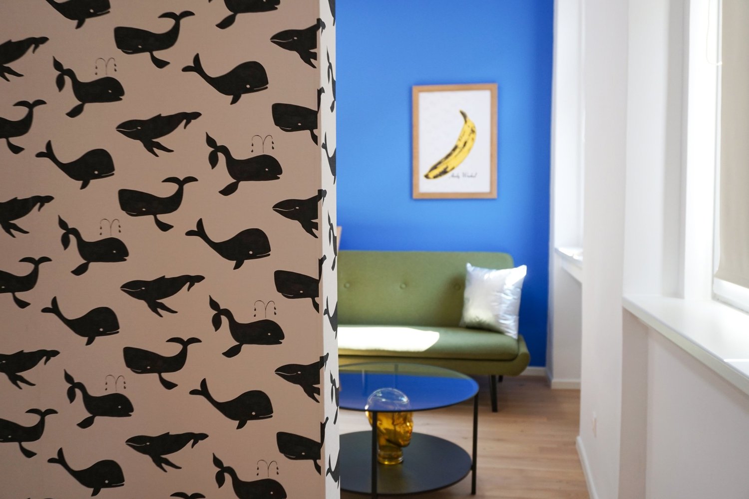 Wohnzimmer mit blauer Wand und grünem Sofa in der Balderichgasse