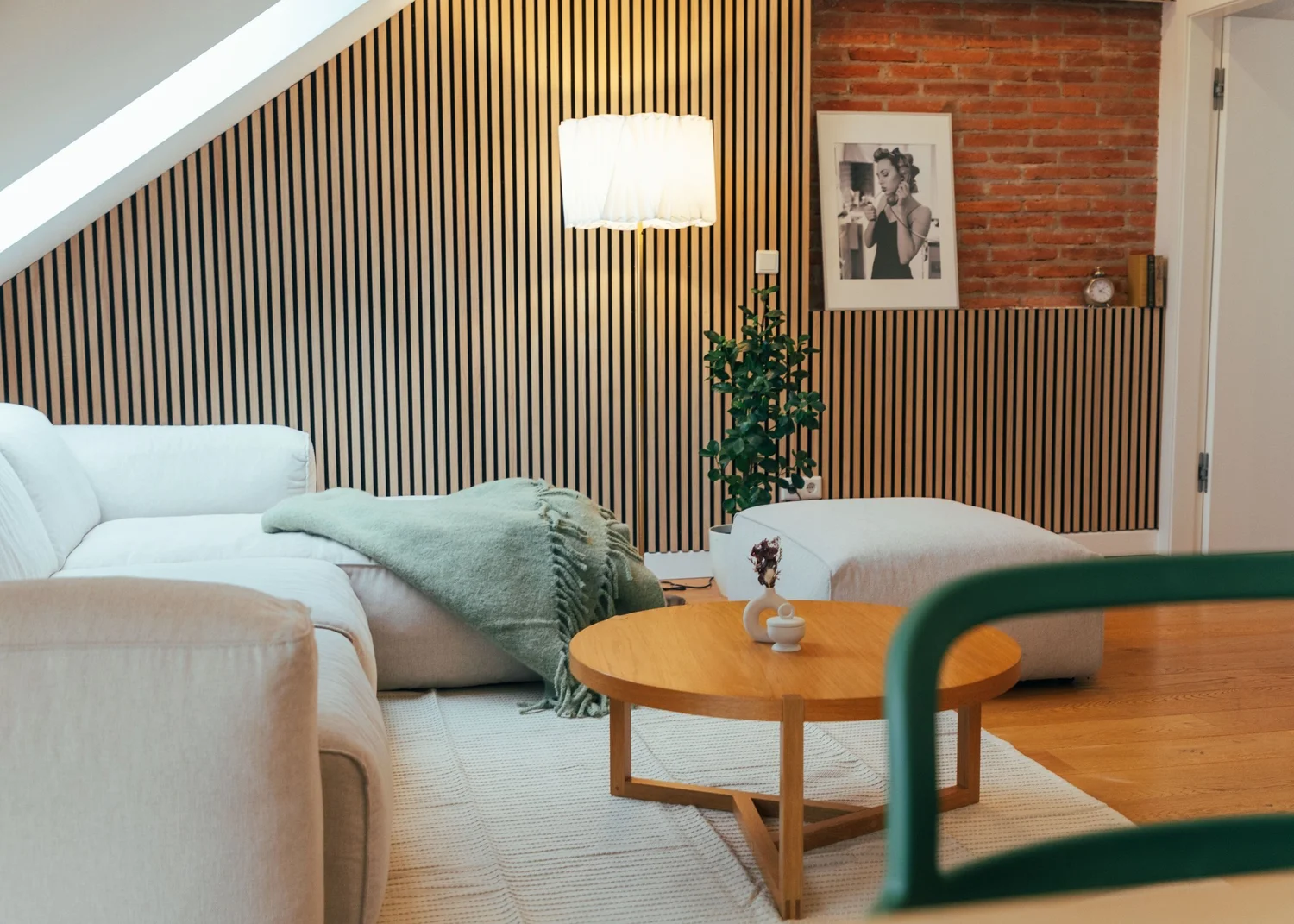 Helles StayOver-Wohnzimmer mit weißem Sofa und Ziegelwand